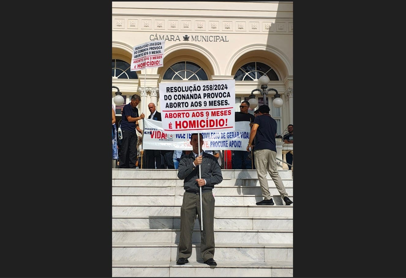 Homem branco segurando cartaz contra aborto