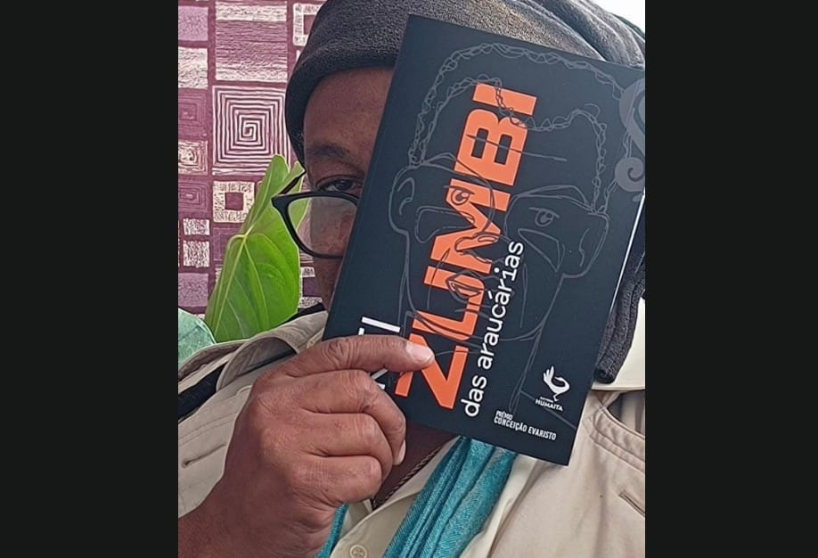 homem negro segurando livro