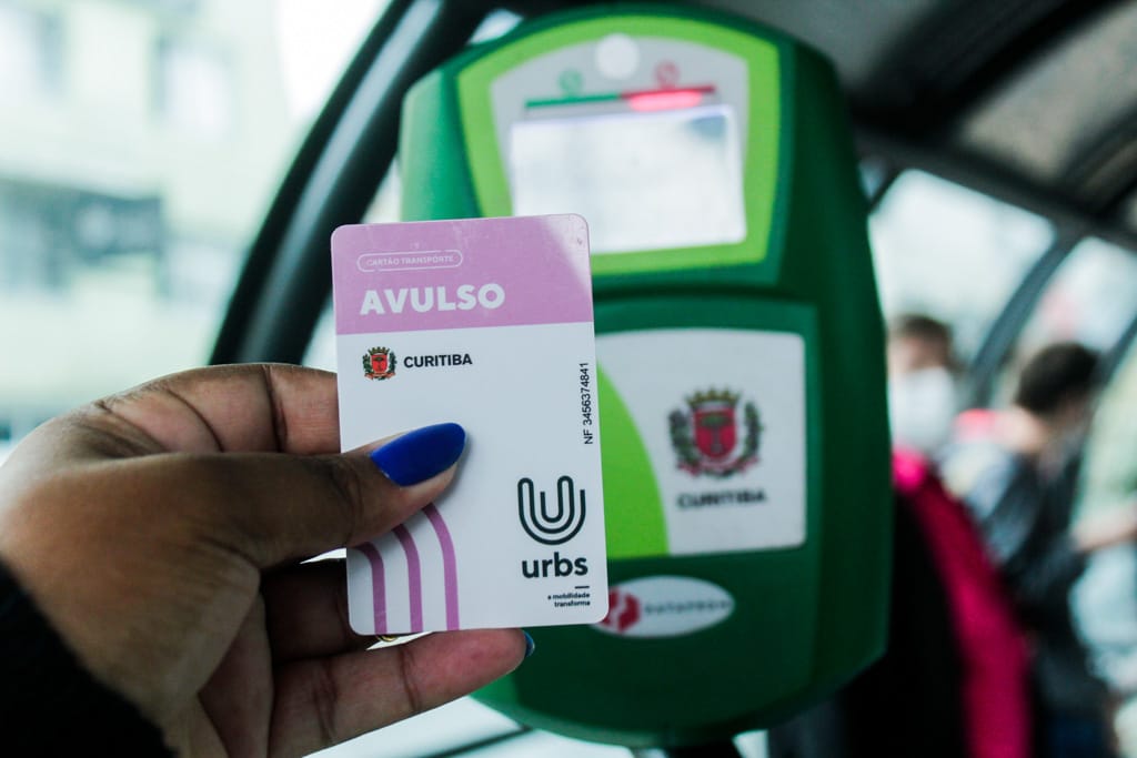 mão negra com unha azul segurando cartão