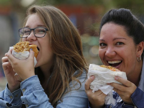 mulheres brancas comendo cachorro quente