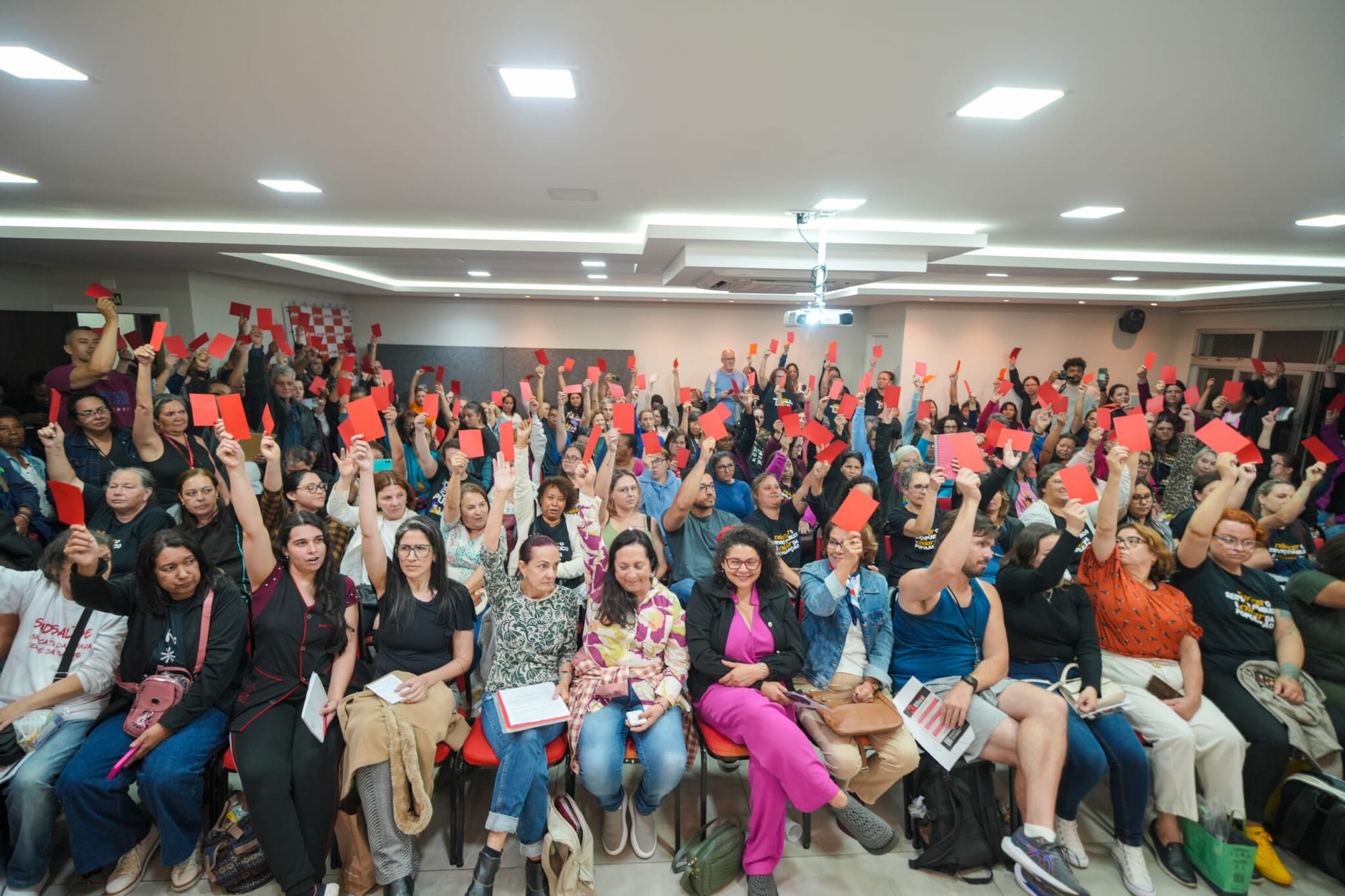 trabalhadoras do sismuc com cartão vermelho levantado