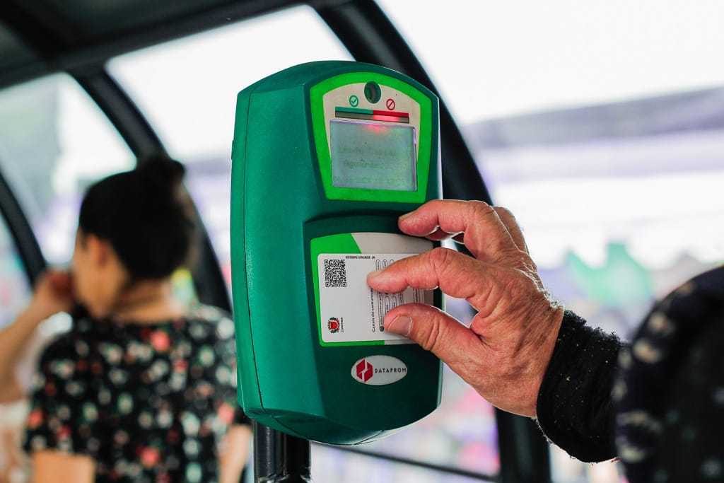 mão de idoso branco usando cartão de ônibus