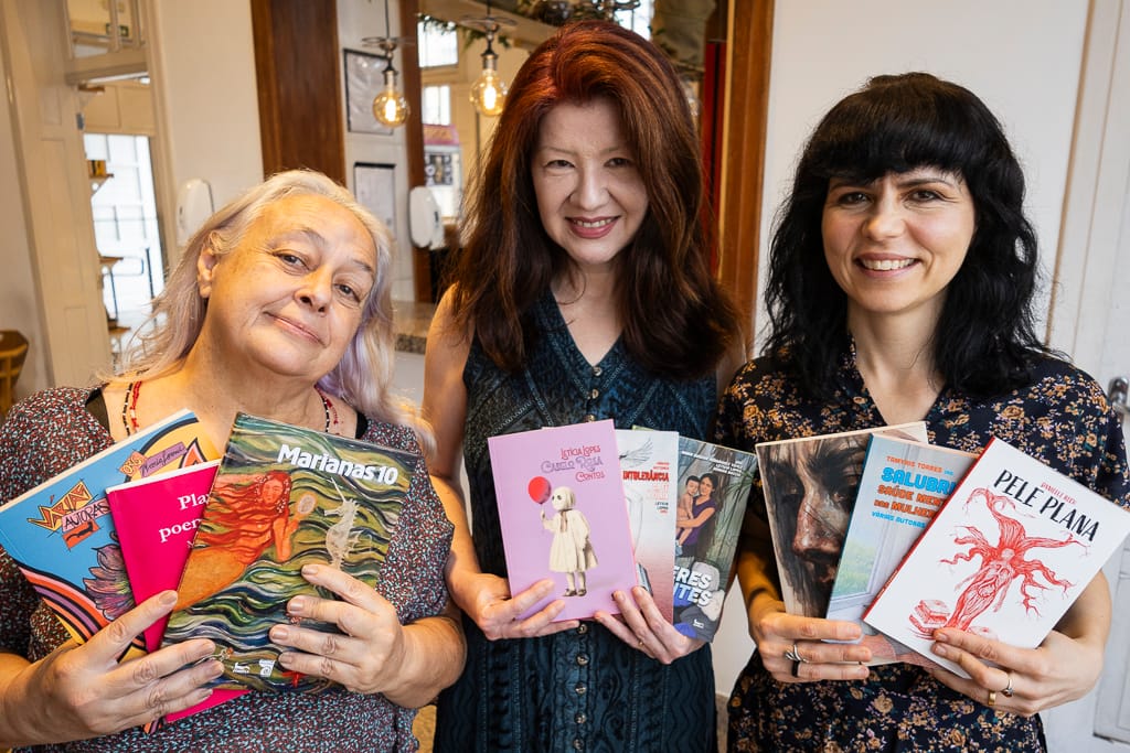 mulheres sorrindo segurando livros