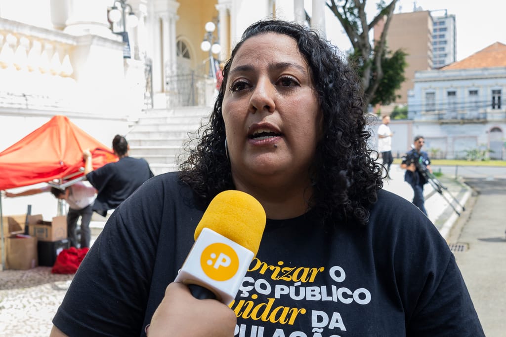 mulher preta com cabelos cacheados falando ao microfone