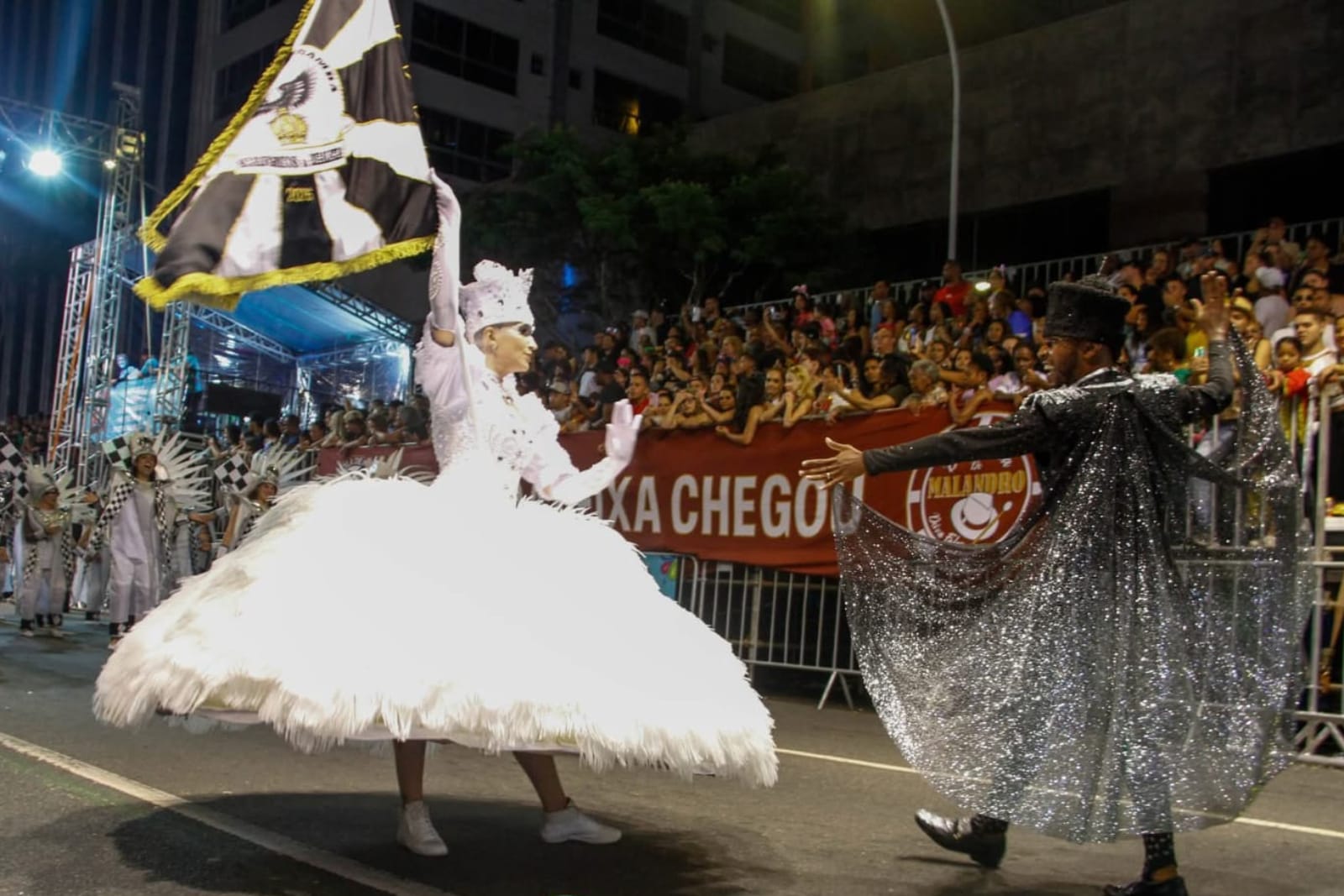 Maestro-sala y portaestandarte en un desfile de escuela de samba en el Carnaval de Curitiba con público en las gradas