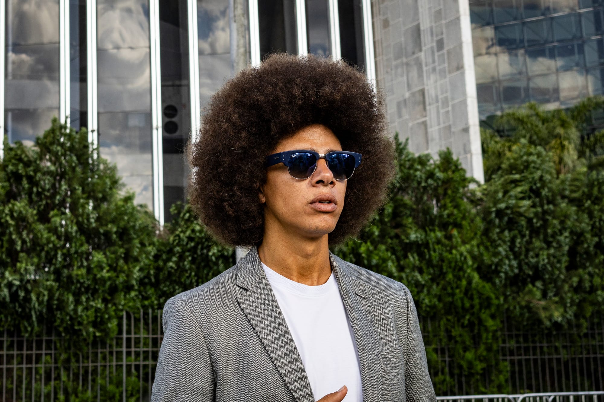 homem negro de paletó e óculos