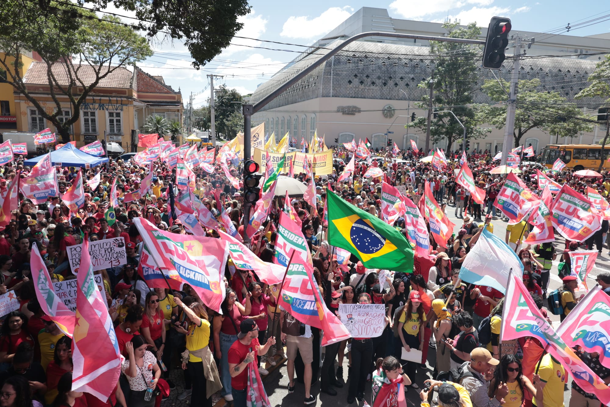 manifestantes segurando bandeiras com nome do presidente Lula com bandeira do Brasil em destaque