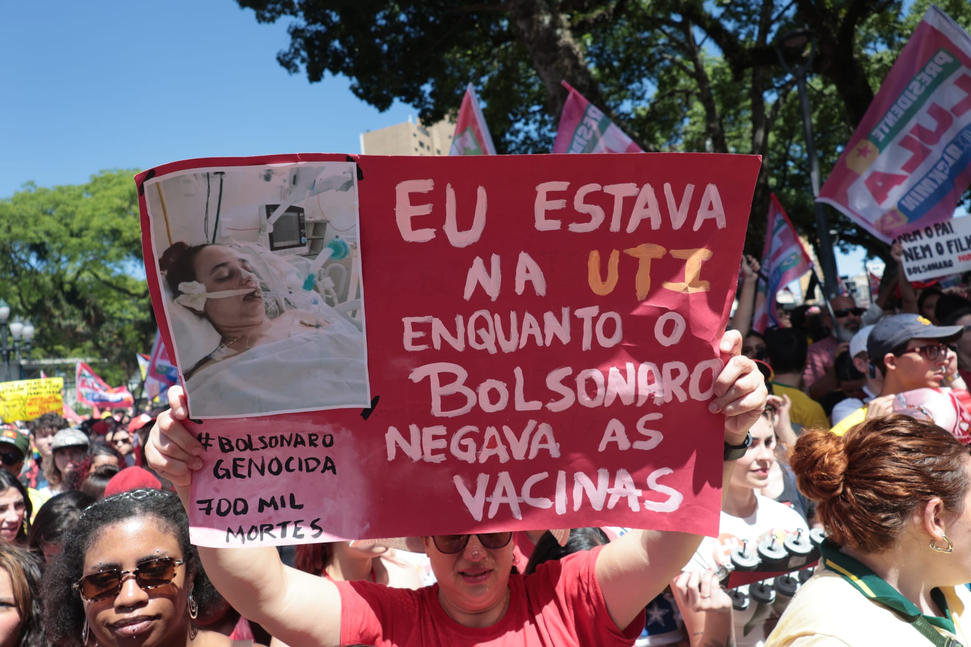 mulher segura foto na qual aparece internada 